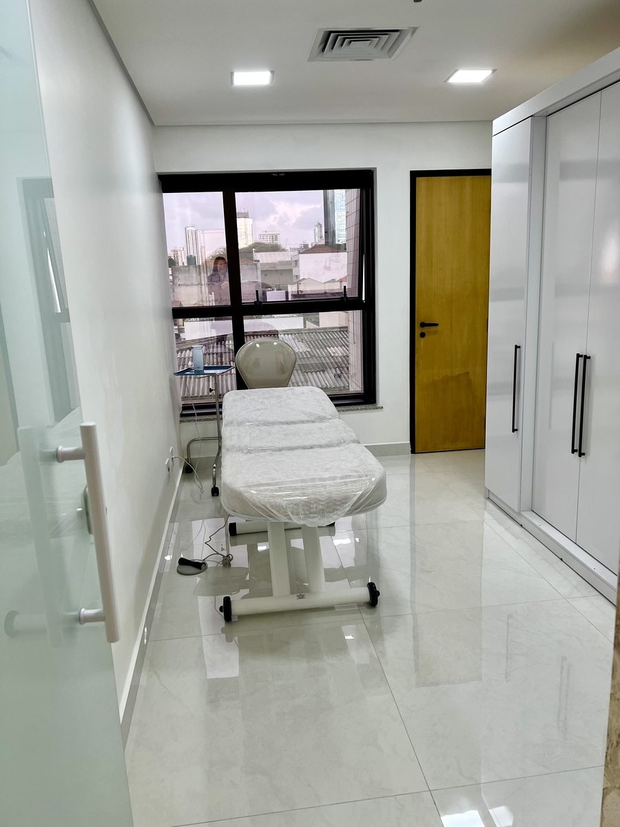 Sala de procedimentos com maca e vista para a cidade